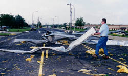 An unidentified man moves large strips ripped from a nearby building